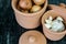 Clay jars with onions and garlic on a black granite table top ready for cooking