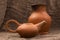 Clay jug and teapot on a background of burlap