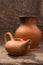 Clay jug and teapot on a background of burlap