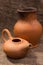 Clay jug and teapot on a background of burlap