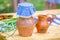 Clay jugs and rustic food on wooden table