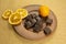 A clay plate with chocolate, tangerine and orange slices stands on a table covered with gray burlap.
