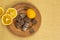 A clay plate with chocolate, tangerine and orange slices stands on a table covered with gray burlap. Top view.