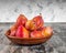 Clay plate with honey plums on gray background