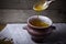 Clay pot with ghee and spoon on linen napkin. Rustic still life.