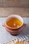 Clay pot with ghee and spoon on linen napkin. Rustic still life.