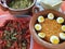 Clay pots filled with rice with boiled egg and pork rinds in green sauce, container with nopales and corn tortillas