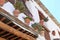 Clay pots with flowers weigh on the wall of a white house with a tiled roof in the old town of Capileira, Spain