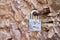 Clay rock wall, rusty metal loop, hook, rusting closed silver metal lock