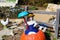 A clay statue of a woman in a blue dress with a blue umbrella sitting on top of a pumpkin