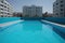 Clean and appetizing blue swimming pool ready to dive in urban surrounding. Generative AI