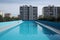 Clean and appetizing blue swimming pool ready to dive in urban surrounding. Generative AI