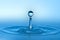 Clean blue drop of water splashing in clear water