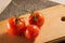 Clean bright tomatoes lie on a wooden board