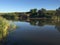 Clean calm river with mirrored water and green banks