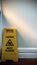 Clean Caution Wet Floor sign is behind the door. Vertical photo image.