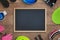 Clean chalkboard surrounded by ski equipemnt on wooden table