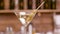 Clean close up parallax shot of a martini glass garnished with olives