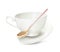 Clean cup with saucer and teaspoon in flight on background