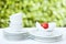 Clean dishes and cups on white tablecloth on green background