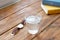 Clean glass of water on a wooden table while reading work books a clock to remind you to regularly take water a healthy lifestyle