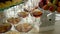 Clean glasses filled with alcohol stand on an elegant glass table at a buffet