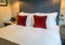 Clean luxury king size bed with many pillows in master hotel room