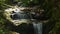 Clean mountain fresh stream with running clear water surrounded by boulders of stones and moss. The beautiful nature of