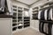 Clean and organized walk-in closet with custom shelving, hanging racks, and ample storage space. Generative AI