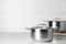 Clean saucepans on table against light background