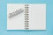 Clean spiral note book for notes and messages and october wooden calendar bar on blue background. Minimal business flat lay