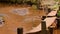 Clean stream of water flowing over the red soil of Cambodia.