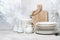 Clean tableware, cutlery and kitchen utensils on white table