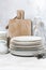 Clean tableware, cutlery and kitchen utensils on white table, vertical