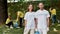 Clean up day. Two happy eco activists wearing uniform and rubber gloves smiling at camera while cleaning forest from