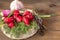 Clean washed fresh vegetables radish  dill  arugula  garlic  green onions with drops of water on a wooden brown table.