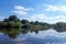 Clean water in the river. The water mirror reflects white clouds.