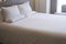 Clean white bed in hotel. White comfortable pillow on bed in bedroom. Bed sheets and pillows.