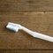 The clean white toothbrush on old wooden planks