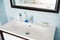 Clean white washbasin with soap and toothbrush in blue bathroom decor with mirror