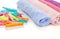 Clean and wrapped towels and many plastic clothespins on a white surface - laundry, cleaning