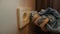 A cleaner\\\'s hand carefully wipes a blue cloth of an electric socket