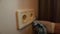 A cleaner\\\'s hand carefully wipes a blue cloth of an electric socket