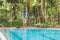 Cleaner of the swimming pool . Man in a blue shirt with cleaning