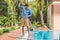 Cleaner of the swimming pool . Man in a blue shirt with cleaning equipment for swimming pools, sunny