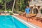 Cleaner of the swimming pool . Man in a blue shirt with cleaning equipment for swimming pools, sunny