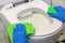 The cleaner washes the toilet bowl with detergent with a rag and washcloth. Cleaning to create hygiene