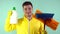 A cleaner in a yellow suit and yellow gloves holds a mop in one hand, and in the other a container with liquid on a blue