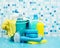 Cleaners and detergents in a bucket, cleaning accessories, blue background with soap bubbles