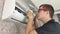 Cleaning the air conditioner from dust, mold and dirt. An air conditioner maintenance worker assesses the level of contamination,